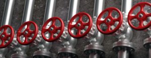 Oil and gas industry. Pipelines and valves with red wheels system on gray wall background, banner. 3d illustration